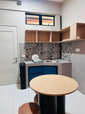 a kitchen with a wooden table and a round table at WiU Cottage, Seri Iskandar in Seri Iskandar