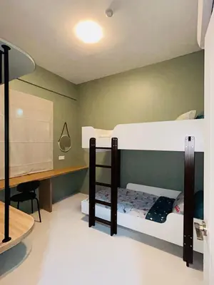 a room with two bunk beds and a desk at WiU Cottage, Seri Iskandar in Seri Iskandar