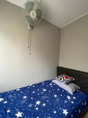 a bedroom with a bed with a fan at Asu Homestay w Private Pool - Batu Gajah,Perak in Batu Gajah