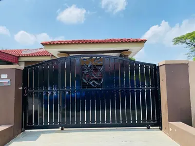 a black gate in front of a house at Asu Homestay w Private Pool - Batu Gajah,Perak in Batu Gajah