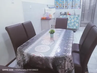 a table with a table cloth on it with a plant on it at Homestay Bajet EM1 Pantai Remis PK in Pantai Remis