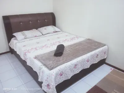 a bed with a black shoe sitting on top of it at Homestay Bajet EM1 Pantai Remis PK in Pantai Remis