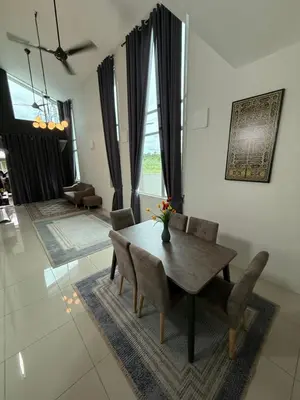 a dining room with a wooden table and chairs at Tropika Homestay Ipoh in Ipoh