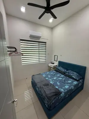 a bedroom with a bed and a ceiling fan at Tropika Homestay Ipoh in Ipoh