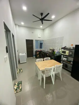 a kitchen with a table and a ceiling fan at Tropika Homestay Ipoh in Ipoh
