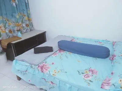 a bedroom with a bed with a blue comforter at Homestay Bajet EM2 Pantai Remis 3 Room in Pantai Remis