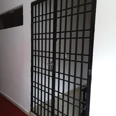 a black cage with a door in a room at Risma Homestay in Batu Ferringhi