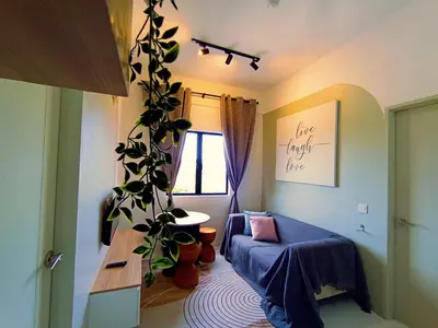 a living room with a blue couch and a plant at Radif Homestay Seri Iskandar#1 in Kampong Bota Road