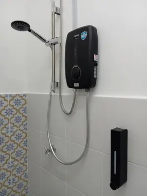 a shower in a bathroom with a dispenser on the wall at Radif Homestay Seri Iskandar#1 in Kampong Bota Road