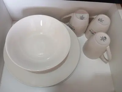 a white plate and two cups on a table at Radif Homestay Seri Iskandar#1 in Kampong Bota Road