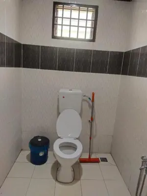 a bathroom with a white toilet and a window at Teratak Desa Cemerlang 1