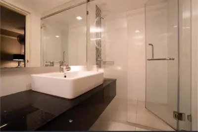 a white bathroom with a sink and a shower at Maritime suite Karpal sign sea view in George Town