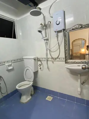 a bathroom with a toilet and a sink and a mirror at Puncak Cameron Holiday in Cameron Highlands