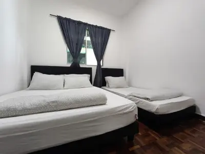 two twin beds in a room with a window at Puncak Cameron Holiday in Cameron Highlands
