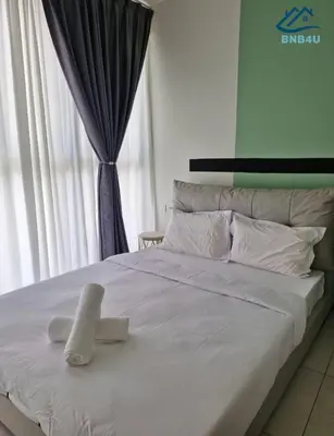 a white bed with a towel on top of it at Urban Suites Apartment In Jelutong George Town in George Town