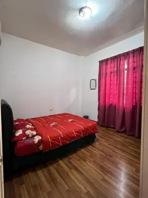 a bedroom with a red bed and a red curtain at Highland Breze Homestay in Tanah Rata