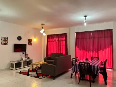 a living room with a table and red curtains at Highland Breze Homestay in Tanah Rata