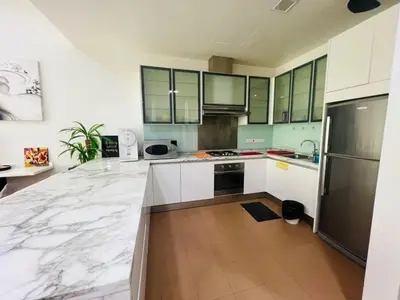 a kitchen with white marble counter tops and a refrigerator at Marina Chic l Stylish 2BR Retreat l Straits Quay in Tanjung Bungah