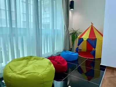 a room with a chair and a kite on the floor at Marina Chic l Stylish 2BR Retreat l Straits Quay in Tanjung Bungah