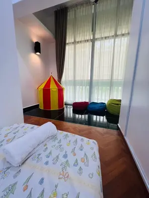 a bedroom with a bed and a window with colorful pillows at Marina Chic l Stylish 2BR Retreat l Straits Quay in Tanjung Bungah