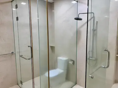 a bathroom with a glass shower and a toilet at Marina Chic l Stylish 2BR Retreat l Straits Quay in Tanjung Bungah