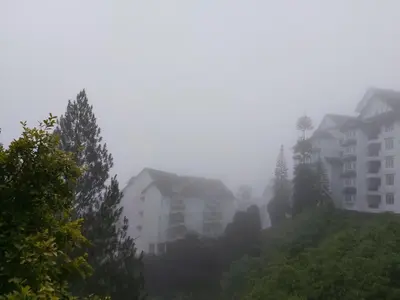 a foggy city with buildings and trees on a hill at A356 Silverpark Resort lifted unit 5th floor in Bukit Fraser