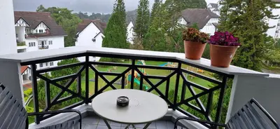 a balcony with a table and potted plants on it at A356 Silverpark Resort lifted unit 5th floor in Bukit Fraser