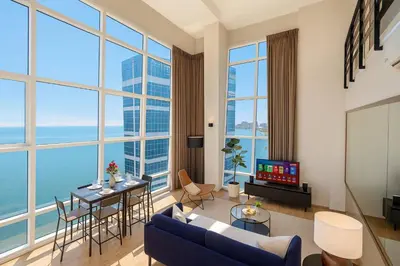 a living room with a view of the ocean at \u3010SeaView\u3011High Floor 2BR Duplex SeaFront-Town 21 in George Town
