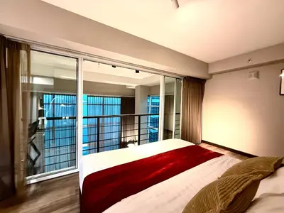 a bedroom with a large bed and a balcony at \u3010SeaView\u3011High Floor 2BR Duplex SeaFront-Town 21 in George Town