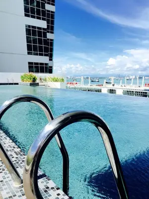 a swimming pool with a metal hand rail next to the water at \u3010SeaView\u3011High Floor 2BR Duplex SeaFront-Town 21 in George Town