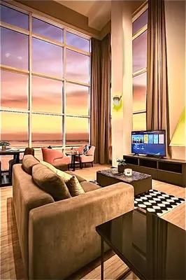 a living room with a couch and a large window at \u3010SeaView\u3011High Floor 2BR Duplex SeaFront-Town 20 in George Town
