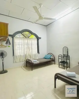 a room with two beds and a window at Homestay AZ Padang Serai in Padang Serai