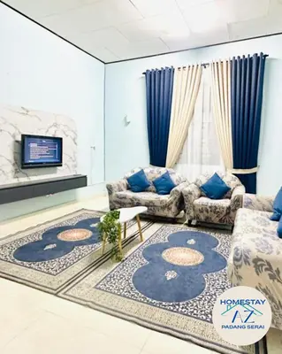 a living room with two couches and a rug at Homestay AZ Padang Serai in Padang Serai