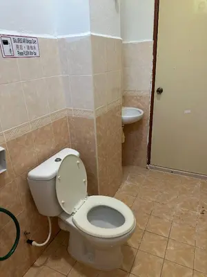 a bathroom with a toilet and a sink at GS Homestay Whole Villa in Gertak Sanggul