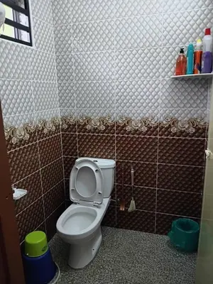 a bathroom with a toilet in a tiled room at Balqis LN Homestay in Taiping