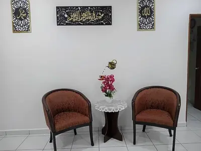two chairs and a table with a vase of flowers at Balqis LN Homestay in Taiping