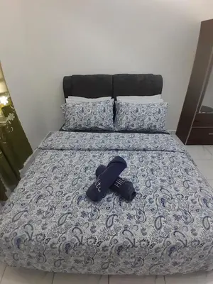 a pair of shoes laying on a bed at Balqis LN Homestay in Taiping