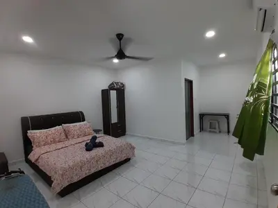 a living room with a bed and a ceiling fan at Balqis LN Homestay in Taiping