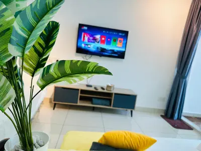 a living room with a tv and a plant at Muji 2B2R 12pax Sunrise Seaview Georgetown Suite in George Town