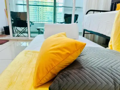 a yellow pillow sitting on top of a bed at Muji 2B2R 12pax Sunrise Seaview Georgetown Suite in George Town