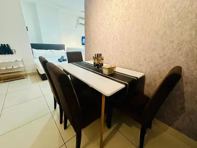 a dining room table with black chairs in a room at Muji 2B2R 12pax Sunrise Seaview Georgetown Suite in George Town