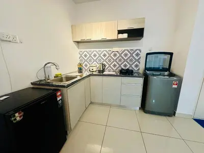 a small kitchen with a sink and a refrigerator at Muji 2B2R 12pax Sunrise Seaview Georgetown Suite in George Town