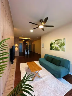 a living room with a blue couch and a ceiling fan at The Cozy Wooden Stay #PalasHorizon#5-7 minutes to Kea Farm in Brinchang