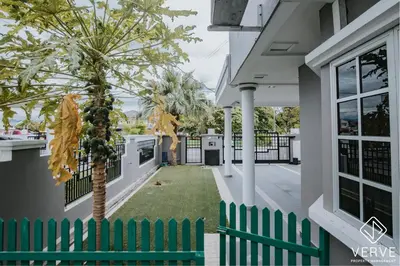 a green fence and a palm tree on a house at Luxe Retreat Homestay by Verve in Ipoh
