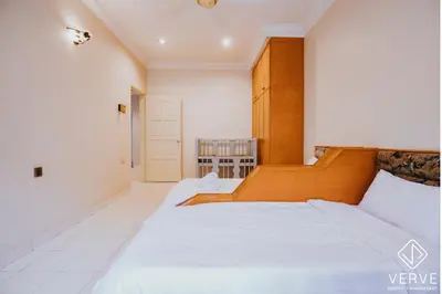 two beds in a room with white walls at Luxe Retreat Homestay by Verve in Ipoh