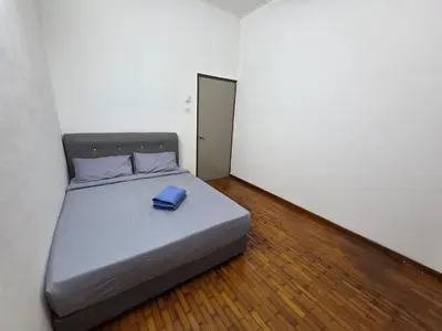 a bed with a blue book on it in a room at Ipoh Stadium Hostel in Ipoh