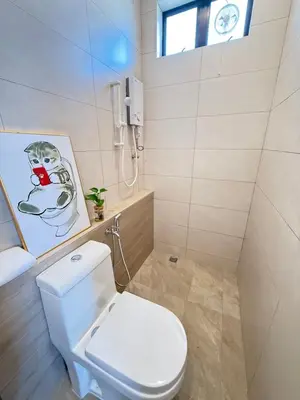 a bathroom with a toilet and a picture on the wall at relaxing home in Bukit Mertajam in Bukit Mertajam