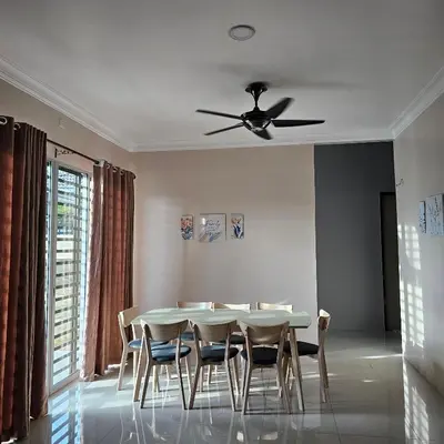 a dining room table with chairs and a ceiling fan at Residensi Lourve Homestay Sungai Petani in Sungai Petani