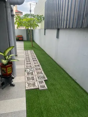 a garden with green grass next to a building at Lake View From Bed Peaceful Getaway Home in Ipoh