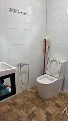 a bathroom with a white toilet and a sink at D'Kebun Lenggong Perak Chalet in Gua Sai